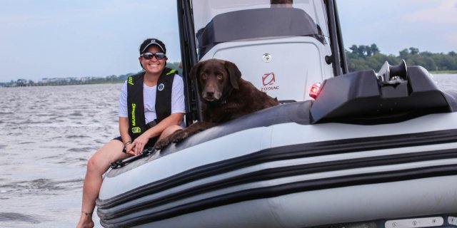 a lady and her dog on a boat in gordon bay marine zodiac open 5.5